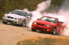 A pair of 2003 Ford Mustang Cobras doing burnouts