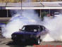 Chevy Chevelle blistering the rear tires look in the background, there is a police car in the smoke