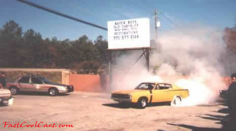 Old Mopar doing burnout with cop car in background?...Cool.