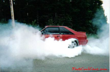 Red Ford Mustang GT doing burnout.